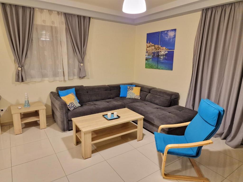comfy center rodos - sweethome في Asgourou: غرفة معيشة مع أريكة وطاولة وكراسي