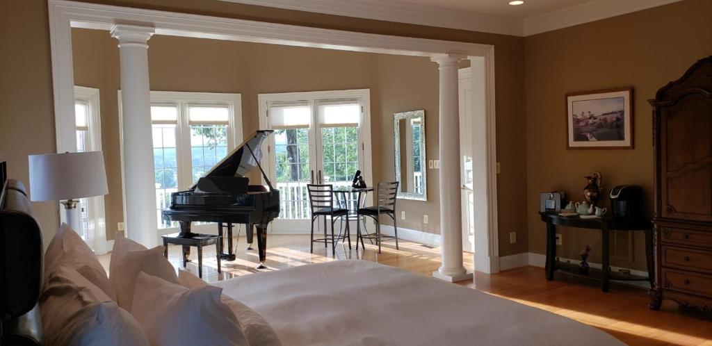 a bedroom with a bed and a grand piano at The Manor at Courtland Farm in Aldie