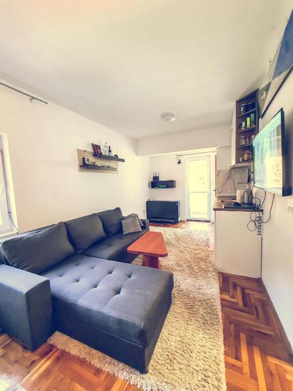 a living room with a blue couch and a table at The spots - 300m from the Gondola in Brzeće