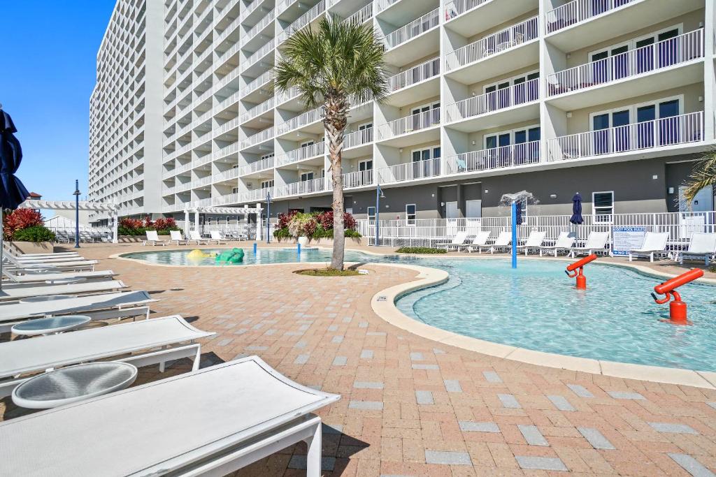 - une piscine avec des chaises longues et un palmier dans l'établissement Laketown Wharf Resort by Panhandle Getaways, à Panama City Beach
