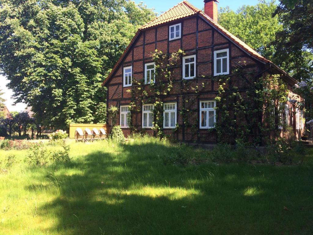 una casa grande con un campo de hierba delante de ella en Wendlandhof Lüggau en Dannenberg