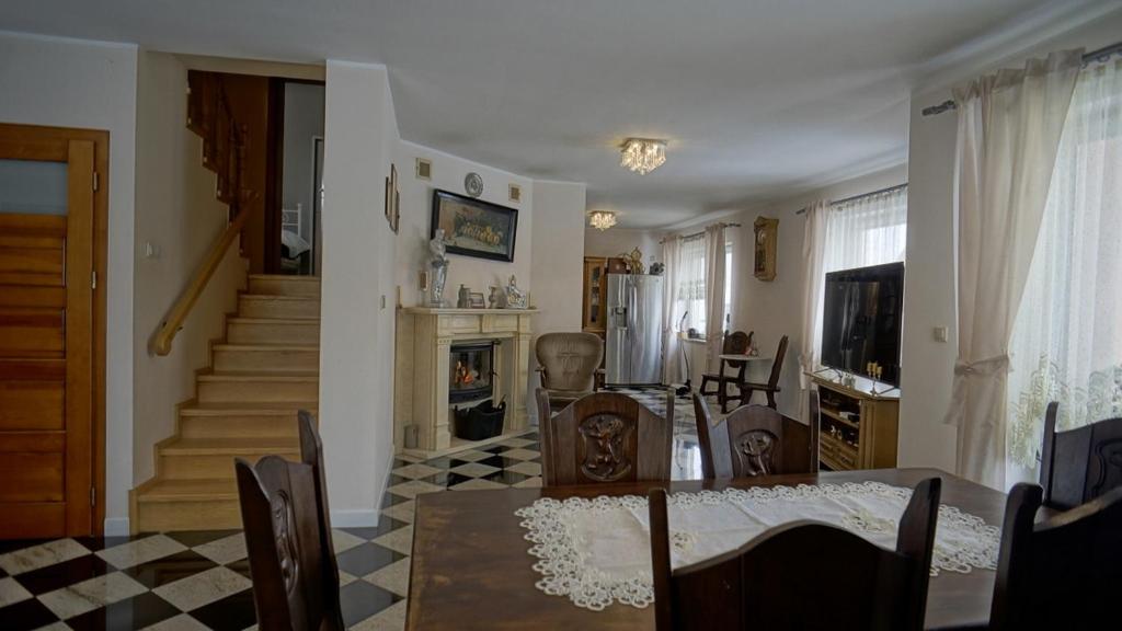 uma sala de estar com uma mesa de jantar e uma lareira em Willa Raj - Apartamenty nad jeziorem KA-BOATS em Rajgród