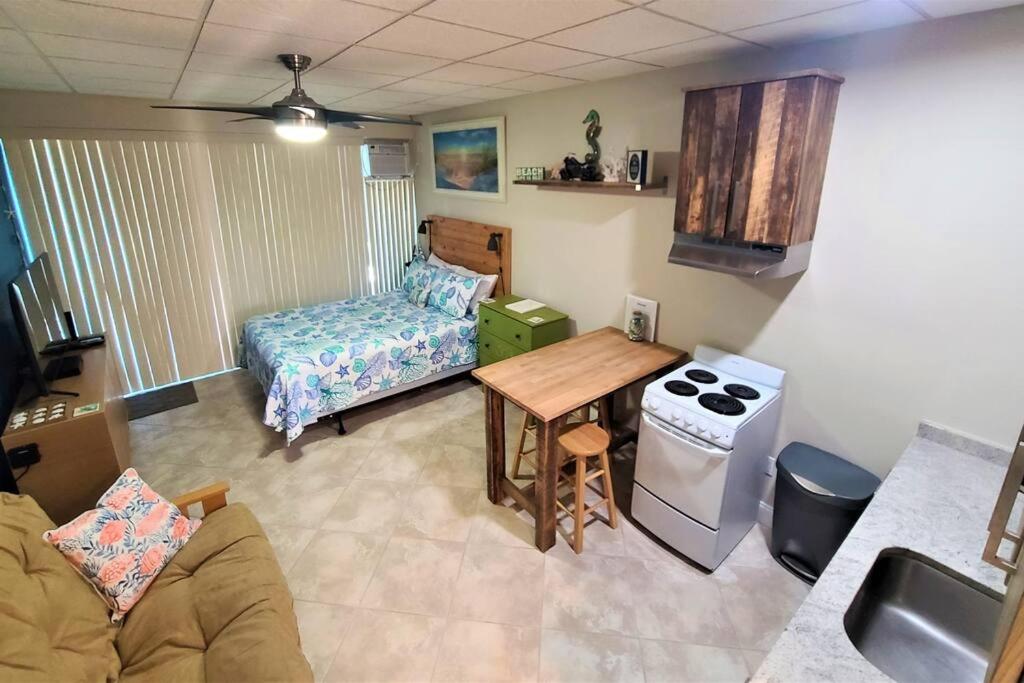 a living room with a couch and a table and a stove at Comfy Coastal Beach Vacation in Clearwater Beach