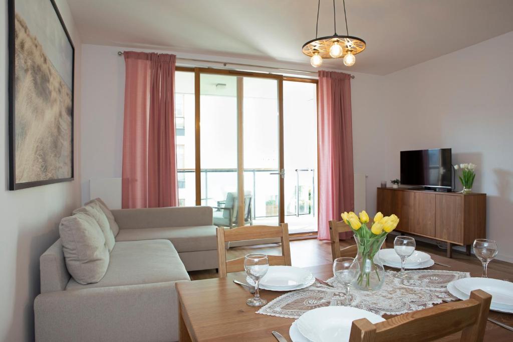 uma sala de estar com um sofá e uma mesa em Luxus Apartament Rodzinny z sauną i siłownią em Gdansk