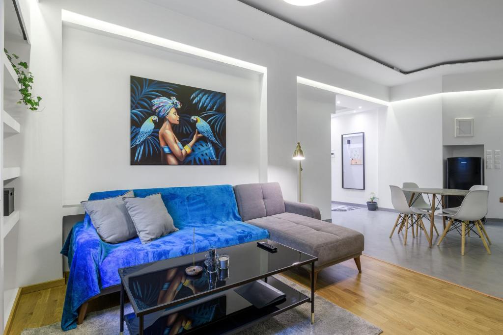uma sala de estar com um sofá azul e uma mesa em Kolonaki Suite in Athens em Atenas