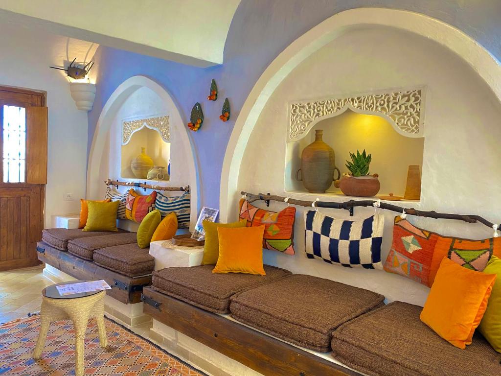 een woonkamer met 2 banken in een kamer met een boog bij Hôtel Djerba Authentique - Au centre de Midoun in Midoun