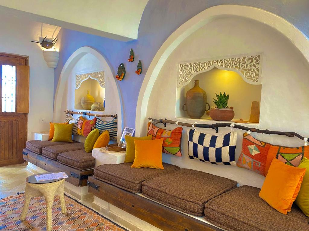 a living room with two couches in a room with an arch at Hôtel Djerba Authentique - Au centre de Midoun in Midoun