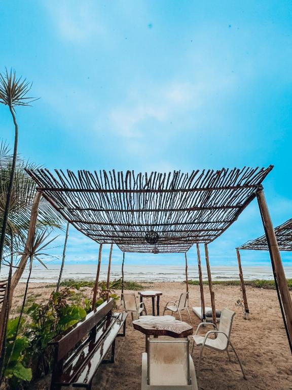 a group of chairs and tables on a beach at Pousada Casa Boa Milagres in Barra do Camaragibe