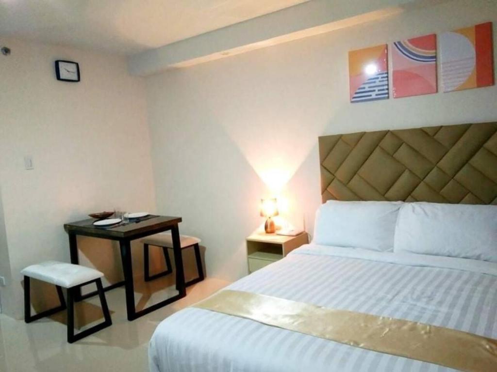 ein Hotelzimmer mit einem Bett und einem Tisch mit einer Lampe in der Unterkunft Stunning Studio Type - 1641 - 16th Flr Persimmon in Cebu City