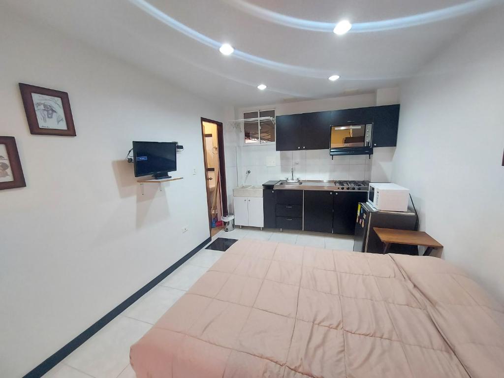 cocina con cama grande en una habitación en Apartaestudio Laureles la 33, en Medellín