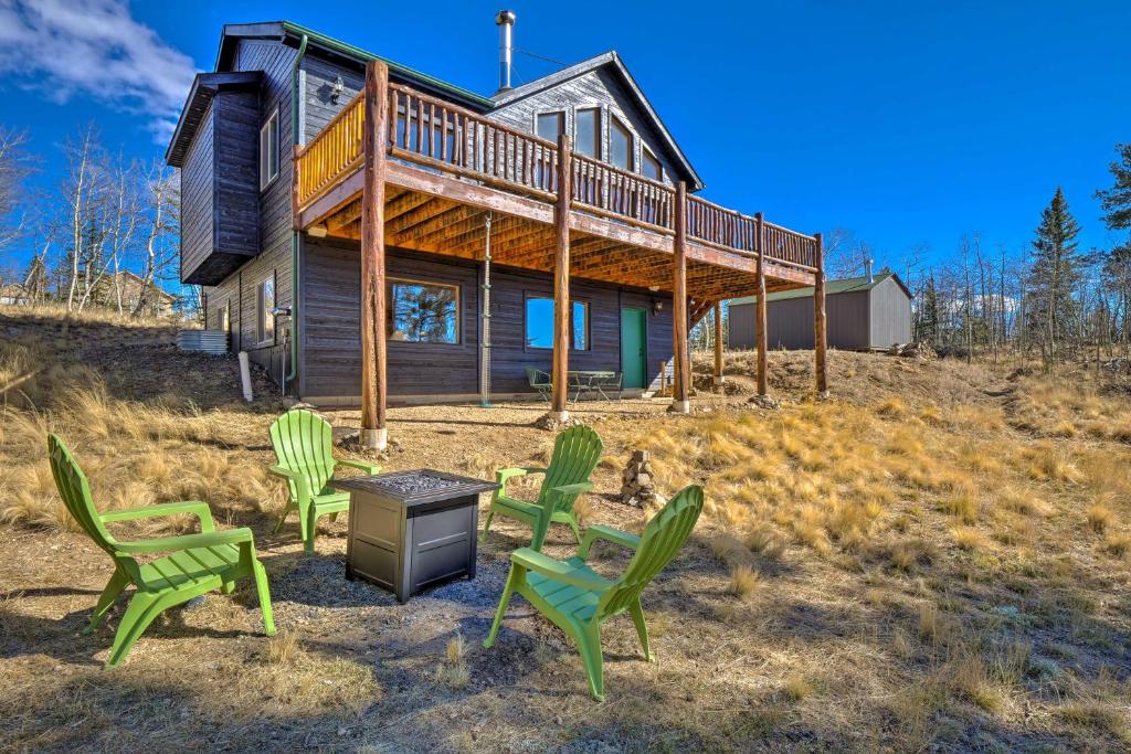 Una casa con sillas verdes delante de ella. en Family-Friendly Jefferson Cabin with Fire Pit!, en Bordenville