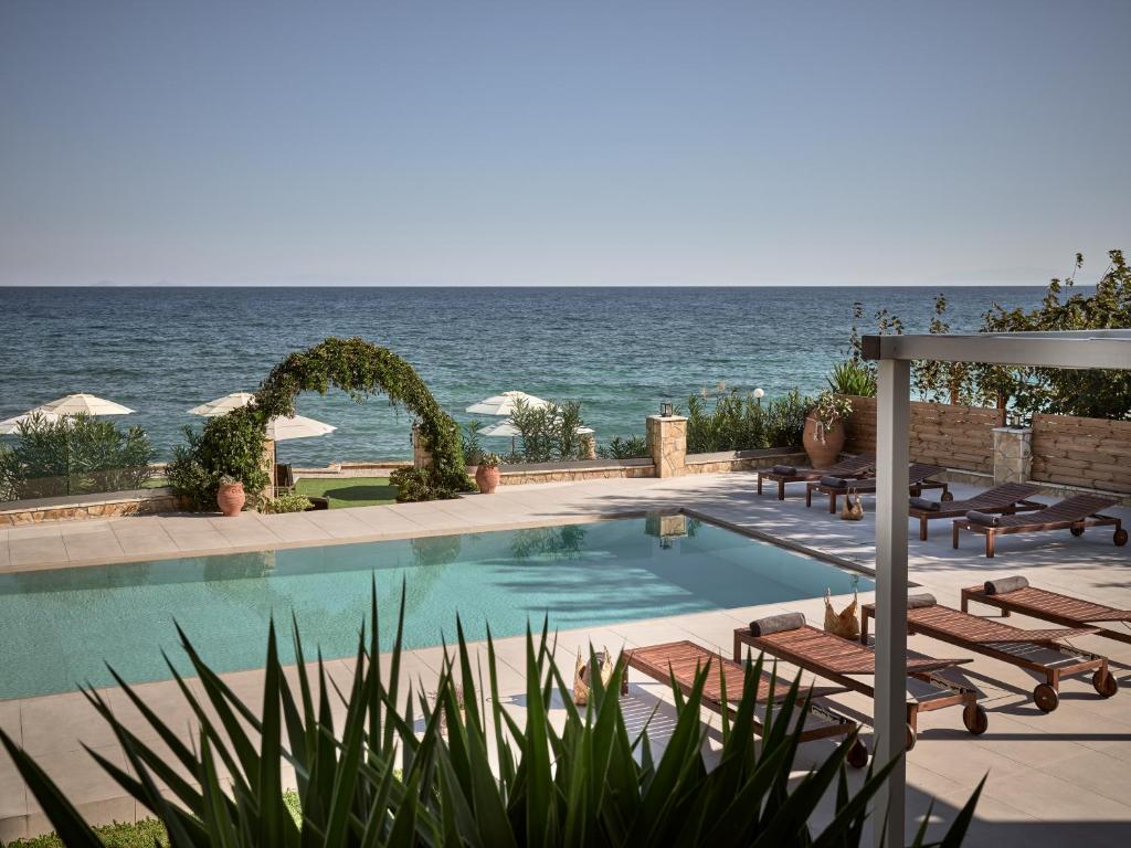 a swimming pool with a view of the ocean at Stefania Apartments in Kipseli