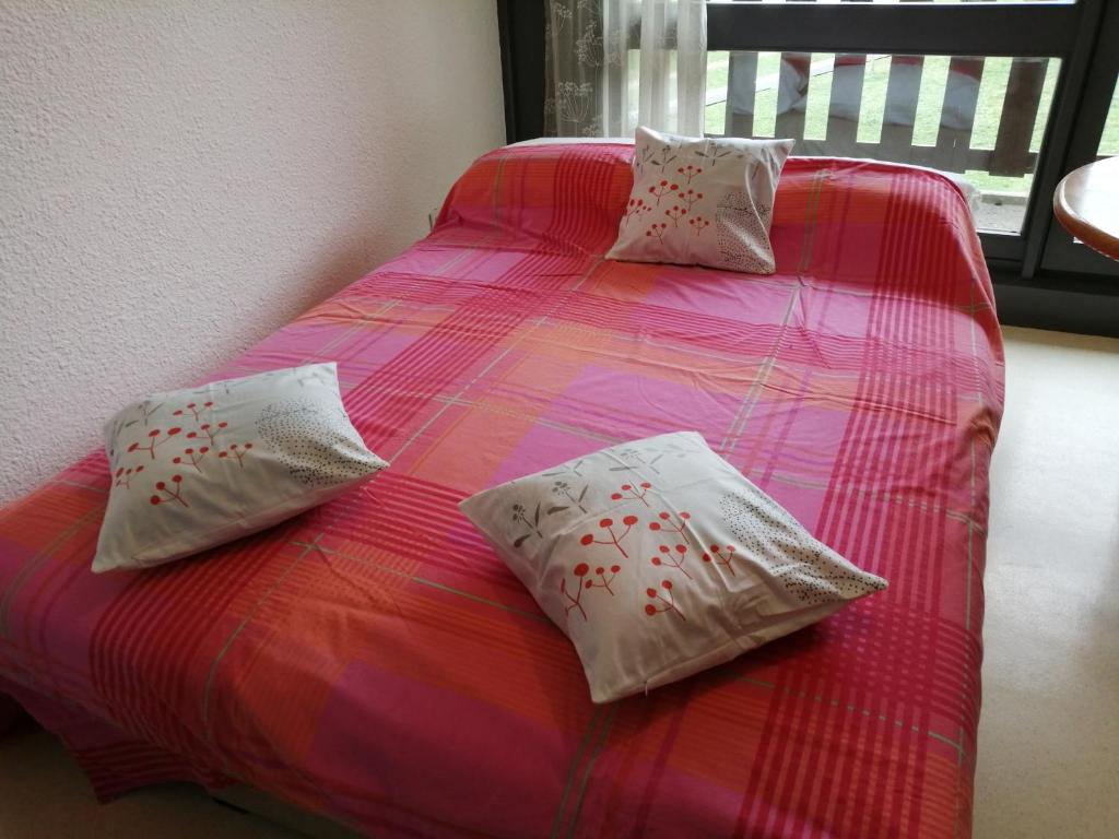 a pink bed with two pillows on top of it at petit nid montagnard in Rousset