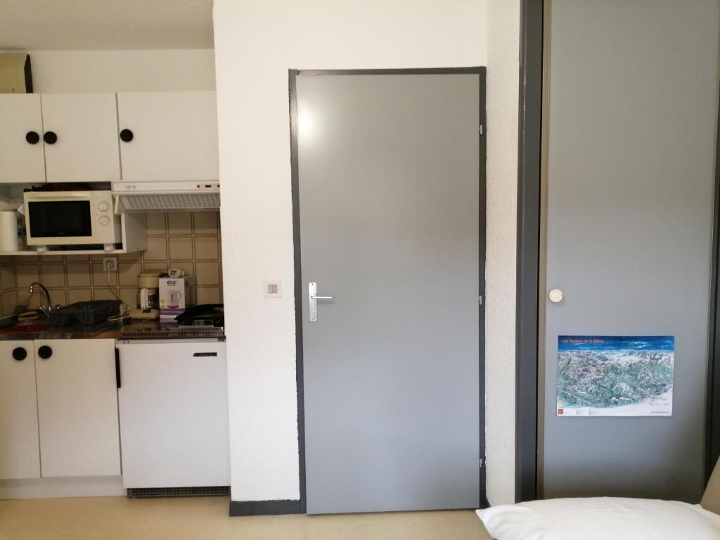 a white door in a kitchen with a microwave at petit nid montagnard in Rousset