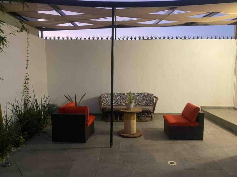 een patio met stoelen, een tafel en een parasol bij Disfruta un agradable alojamiento en Rocky Point in Puerto Peñasco