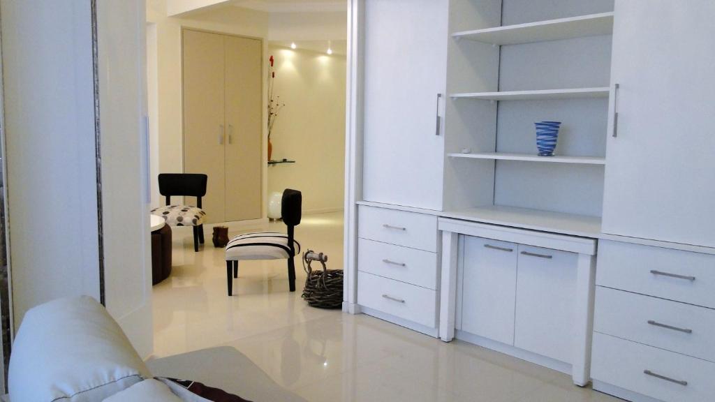 una sala de estar con un armario blanco y sillas en Recoleta Luxury Apartment en Buenos Aires