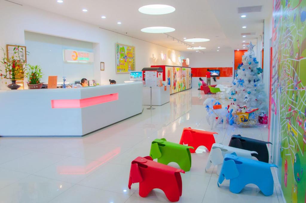 a waiting room with a christmas tree and colorful chairs at Legend Hotel Kaohsiung Liuhe in Kaohsiung