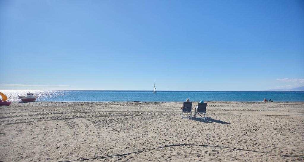 エル・カボ・デ・ガタにあるApartamento Luna Llena Cabo de Gataのビーチの椅子に座って2人