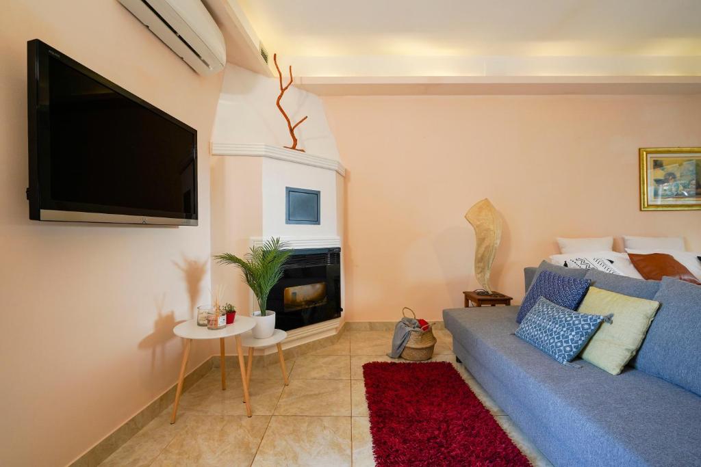 uma sala de estar com um sofá azul e uma televisão de ecrã plano em [-20% OFF] La Corte di Greta - Nature &Peace em Bitetto