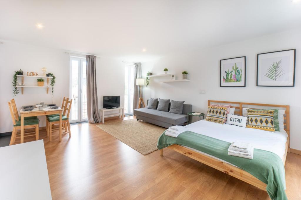 a bedroom with a bed and a living room at Ourique Charm Apartments in Lisbon