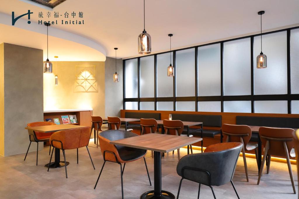 a restaurant with tables and chairs and windows at Hotel Initial-Taichung in Taichung