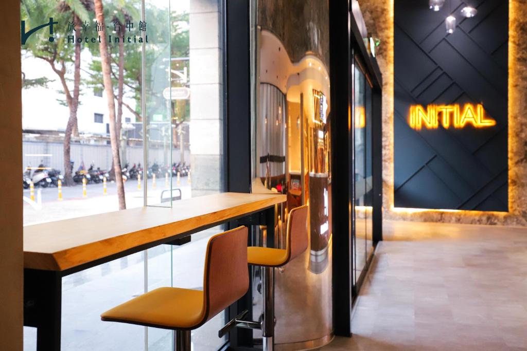 a bar in a store with two chairs and a window at Hotel Initial-Taichung in Taichung