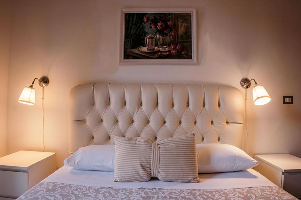 1 dormitorio con 1 cama blanca y 2 lámparas en Elephant's Smile B&B, en Catania