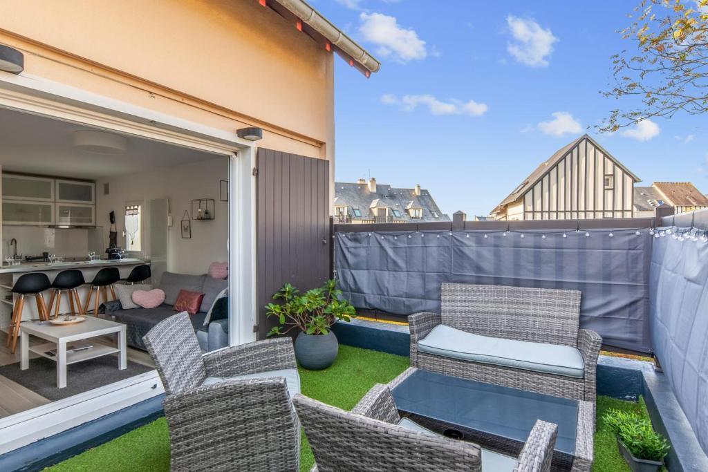 Elle comprend un petit balcon avec des chaises et une table. dans l'établissement Charming duplex with big terrace- Cabourg - Welkeys, à Cabourg