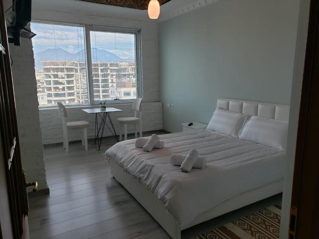 1 dormitorio con 1 cama grande y ventana grande en Agroni Rooms, en Tirana