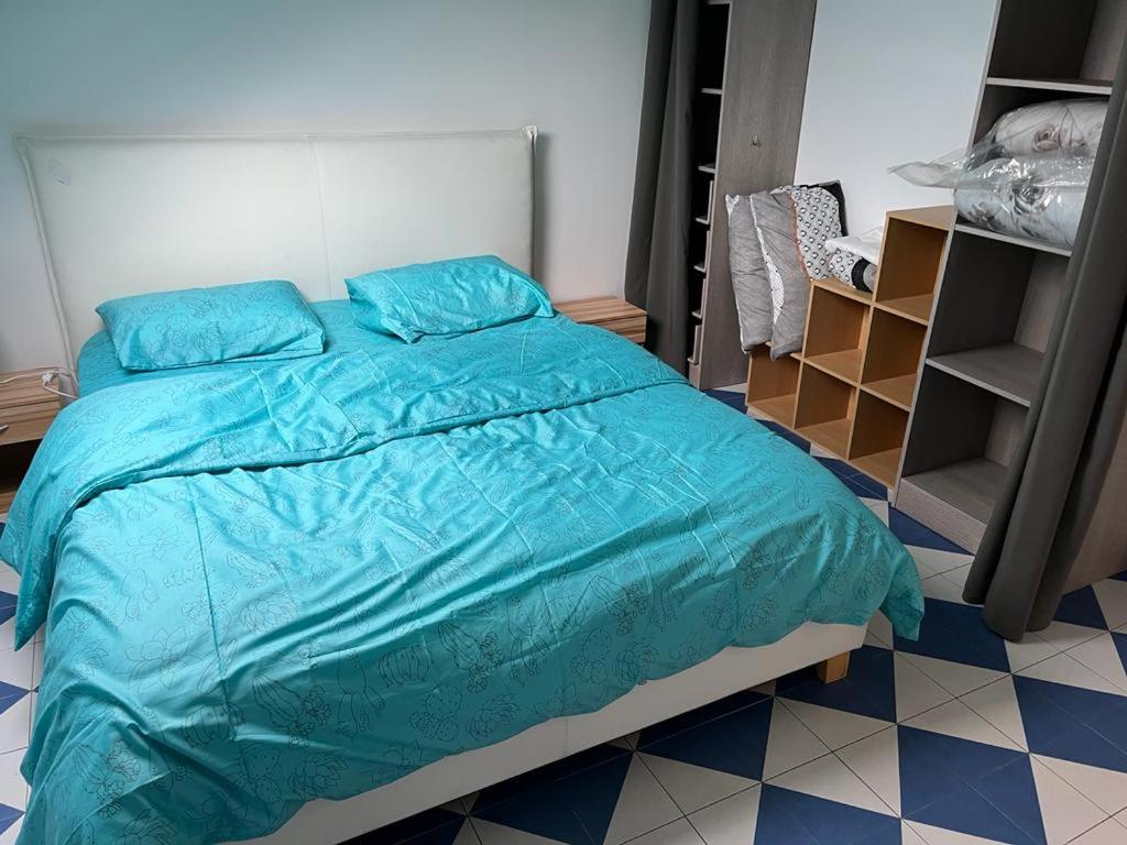 sypialnia z łóżkiem z niebieską kołdrą w obiekcie SUITS & LUXURY Appart Paris Montreuil w mieście Montreuil