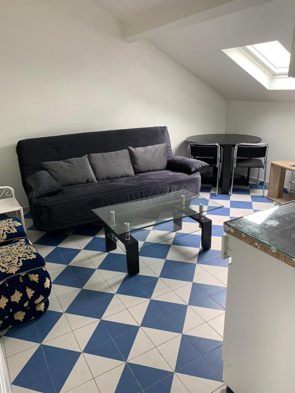 salon z kanapą i niebiesko-białą podłogą w obiekcie SUITS & LUXURY Appart Paris Montreuil w mieście Montreuil