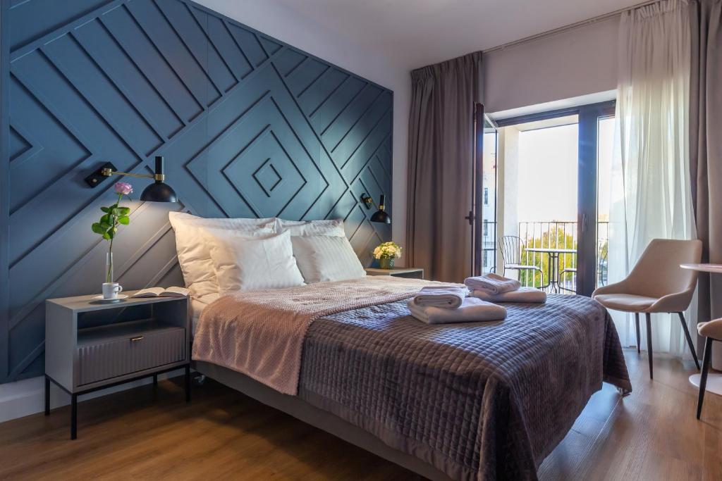 1 dormitorio con 1 cama grande y pared azul en Apartments Kraków Rajska by Magnat, taras, winda, en Cracovia