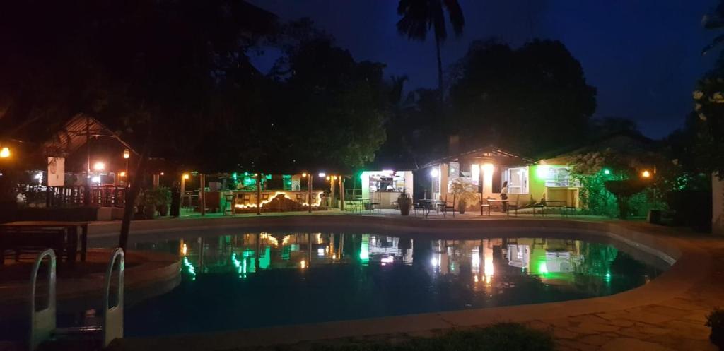 una piscina por la noche con luces encendidas en Makuti Villas Resort, en Kilifi