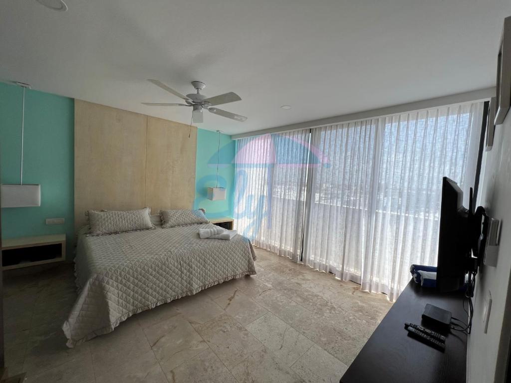 een slaapkamer met een bed en een plafondventilator bij Anah Downtown luxury condo in Playa del Carmen