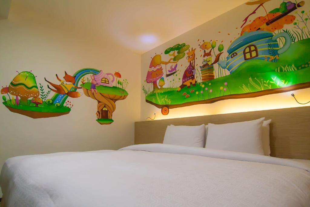 a bedroom with a bed and paintings on the wall at Legend Hotel Kaohsiung Liuhe in Kaohsiung