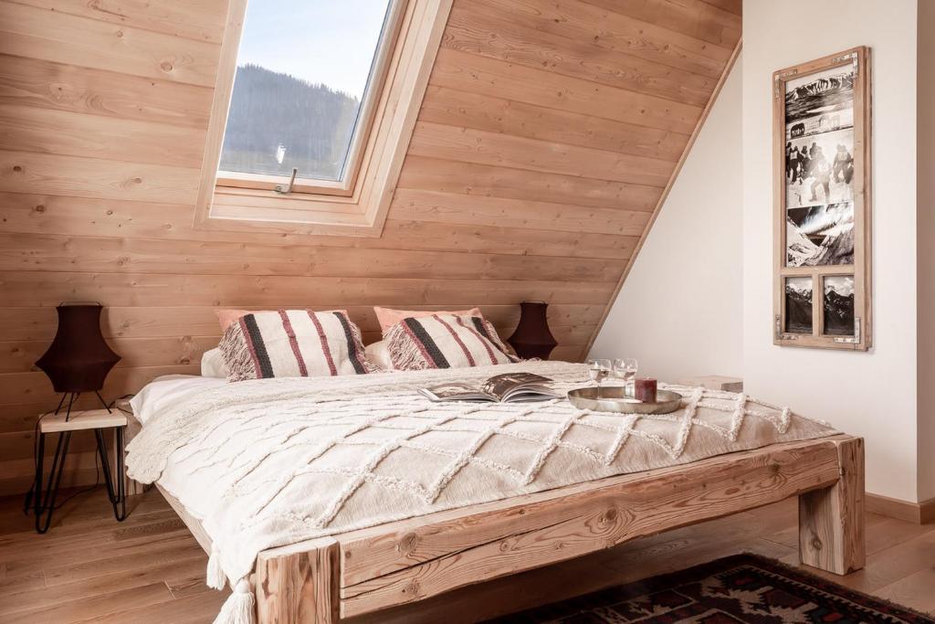 a bedroom with a bed with a wooden wall at TATRA REST in Kościelisko