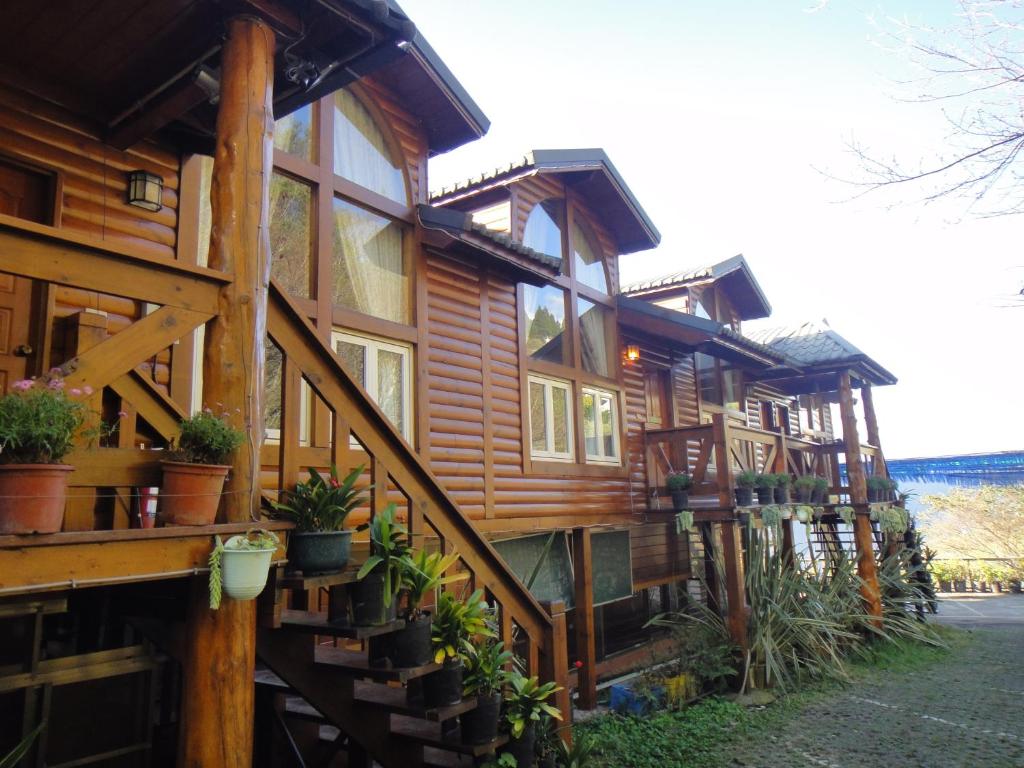 a large wooden house with potted plants on it at Bunbury Fruit Ranch B&amp;B in Ren&#39;ai