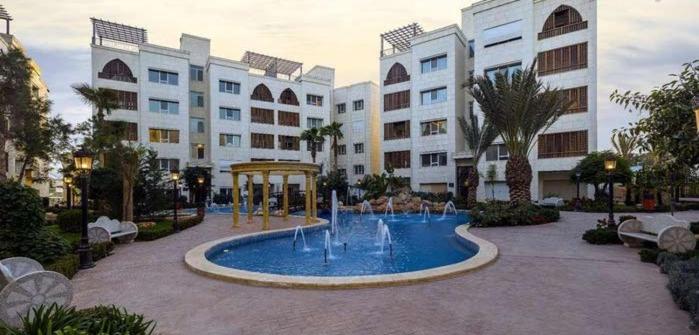 a large building with a fountain in a courtyard at Ritala Royal Residence in Amman