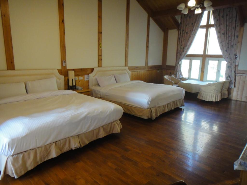 a hotel room with two beds and a large window at Bunbury Fruit Ranch B&amp;B in Ren&#39;ai
