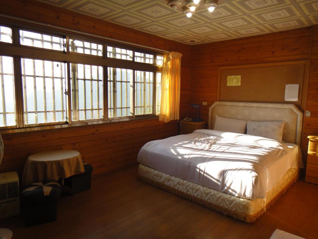 a bedroom with a bed in a room with windows at Bunbury Fruit Ranch B&amp;B in Ren&#39;ai