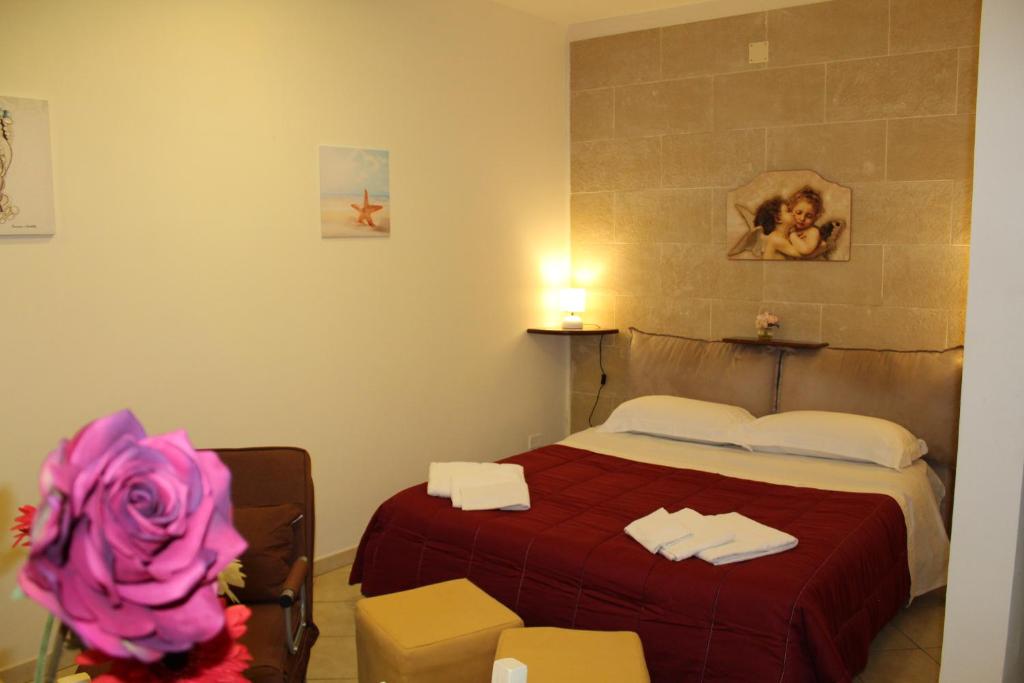 シラクーサにあるイル コンテ ディ カヴールのベッドルーム1室(赤いベッドカバー付)