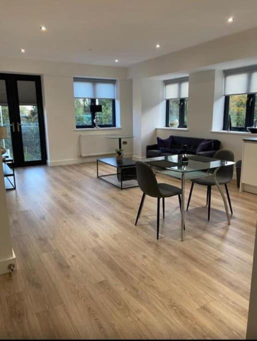 a living room with a table and chairs in it at Brand new luxury apartment with free parking and gym in Olton