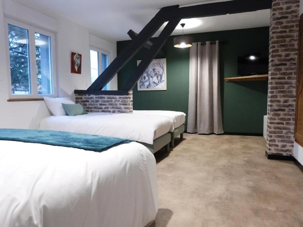 a bedroom with two beds and green walls at Aux Portes des Lacs in Ardres