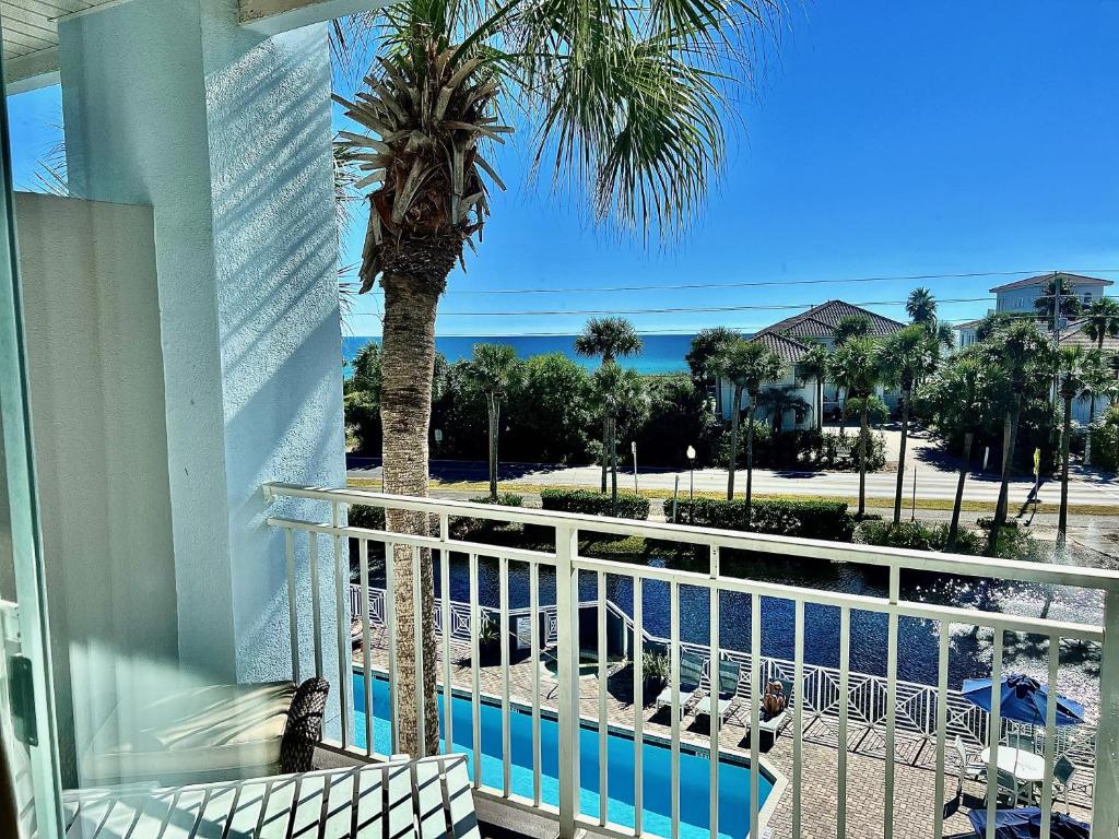 a balcony with a palm tree and a swimming pool at Cabana's @ Gulf Place #308 in Santa Rosa Beach