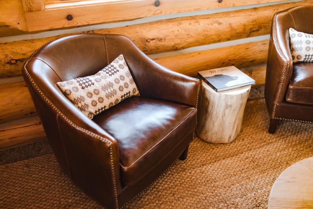 a leather chair with a pillow in a room at Teton Cabins in Moran