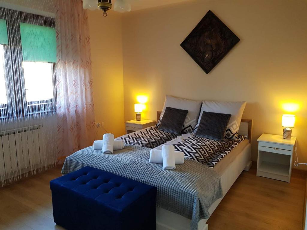 a bedroom with two beds and a blue ottoman at Apartament Leśny in Nowy Targ