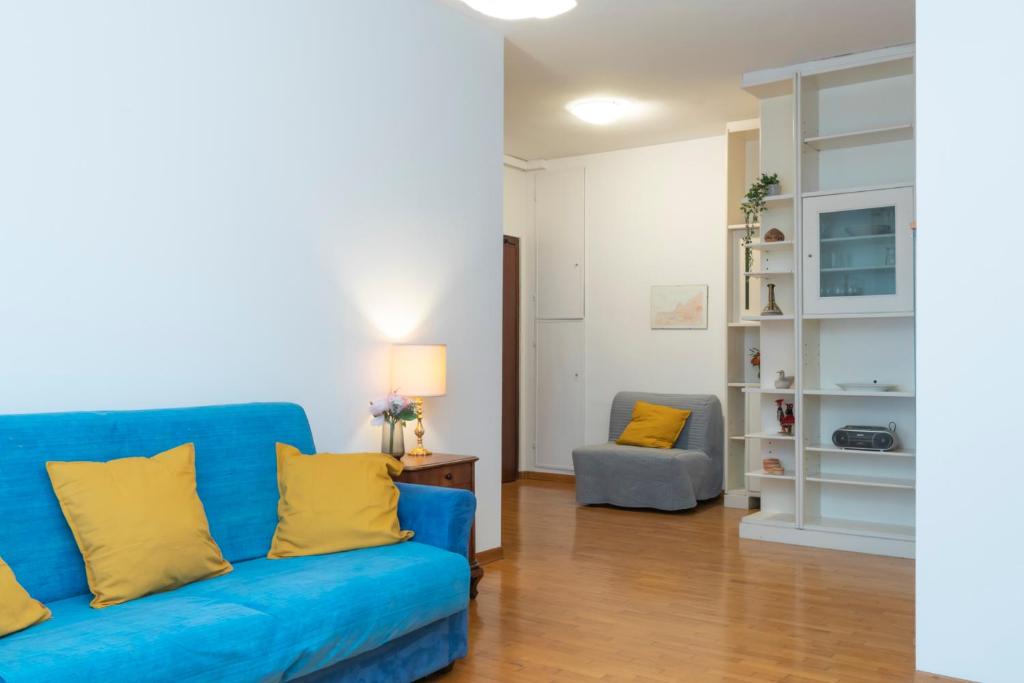 sala de estar con sofá azul y almohadas amarillas en [Mimmi Apartment] Zurigo 12, en Milán