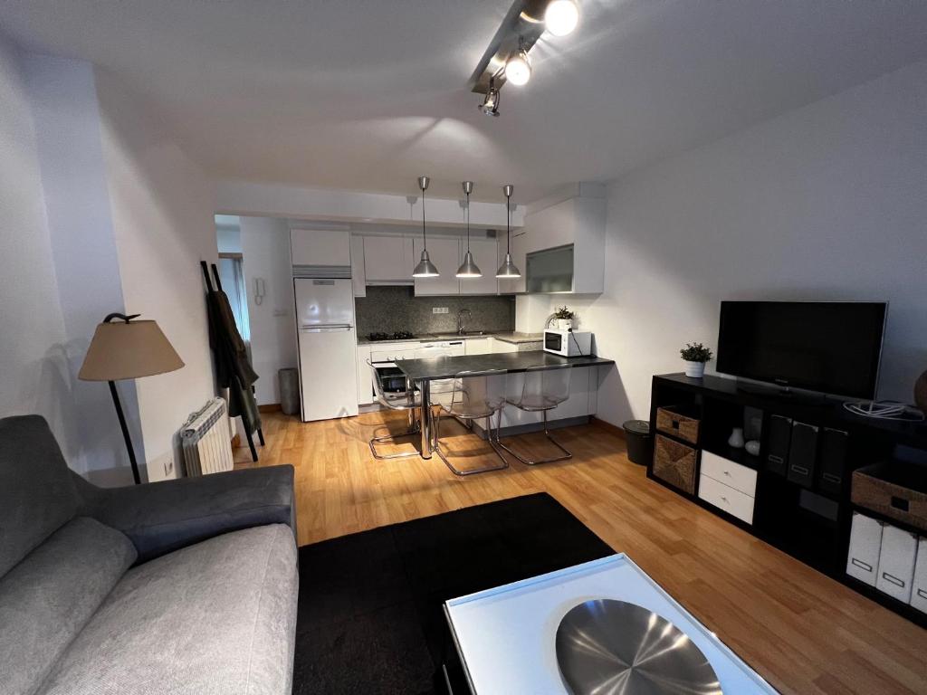 a living room with a couch and a table and a kitchen at Oktheway Santander Street in A Coruña