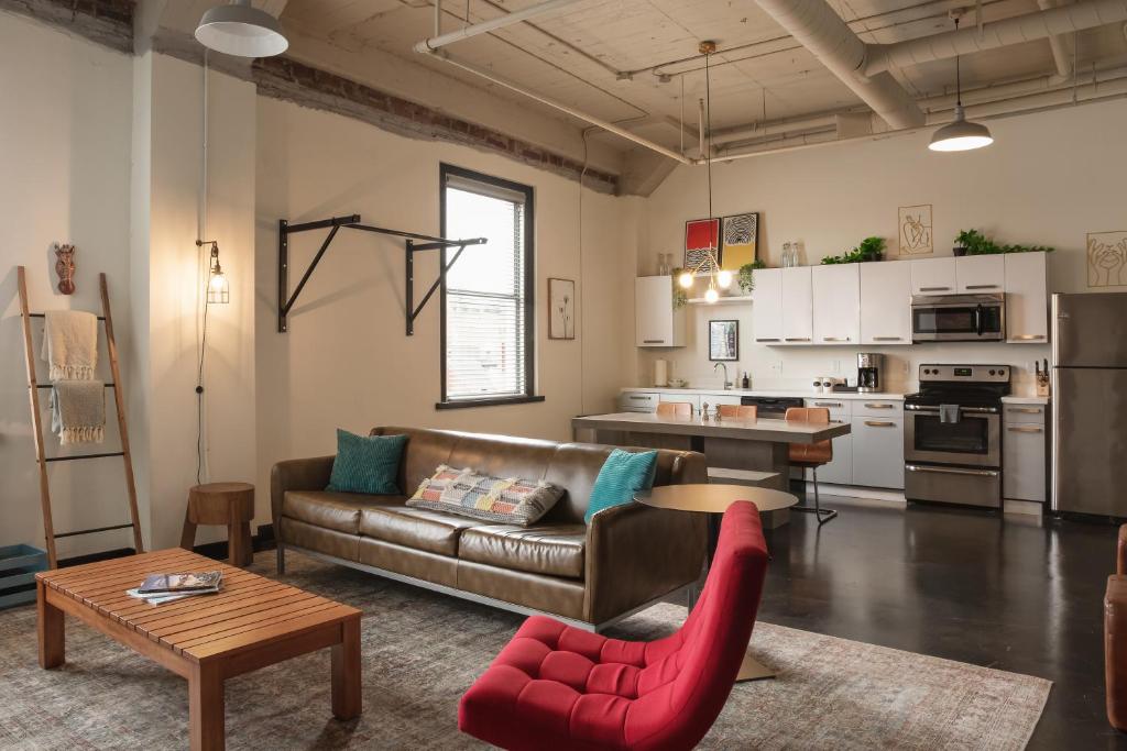 a living room with a couch and a red chair at Hotel Clemons in Chattanooga