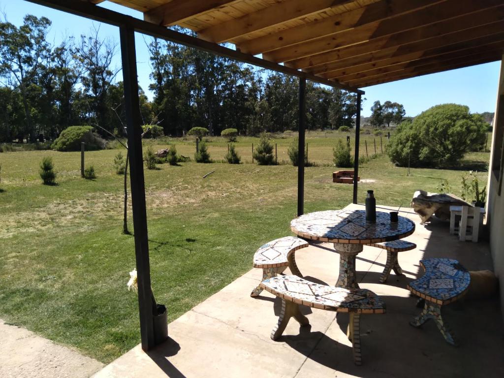 un patio con mesa, sillas y un campo en Alquiler temporario La Florida en Necochea